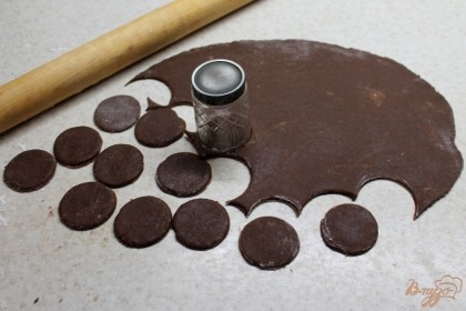 Тесто присыпаем мукой и раскатываем толщиной 1-2 мм. С помощью рюмки вырезаем круги из теста.