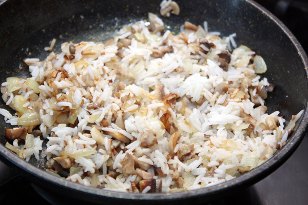 Добавить в сковородку сваренный рис, посолить, поперчить по вкусу, перемешать.