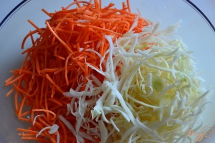 Тонкую соломку из капусты и моркови сложить в салатник. Немного посолить и помять руками.