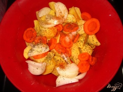 Картофель, лук и морковь очистить. Картофель нарезать дольками. Морковь нарезать кружочками. Лук также большими дольками. Полить растительным маслом, приправить солью и специями, перемешать.