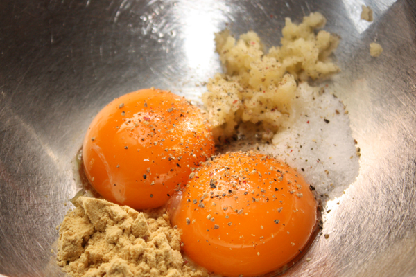В небольшую миску положить 2 свежих яичных желтка, раздавленный или растертый чеснок, соль, перец и немного горчицы. Соль и горчицу лучше класть совсем чуть-чуть, а если надо, добавить в уже готовый майонез.