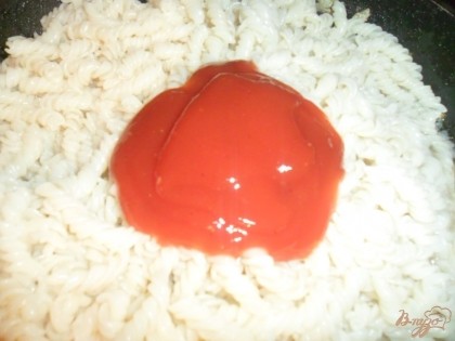 Бросить макароны на горячую сковороду к жареному луку, добавить томатный соус, перемешать.