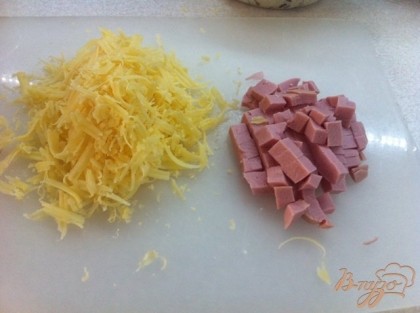 Нарезаем мелким кубиком колбасу, трем на терке сыр.