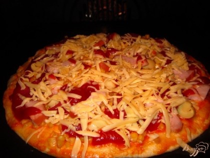 Поставьте пиццу в духовку на 15 минут при температуре 220С. В конце приготовления посыпьте натертым сыром.