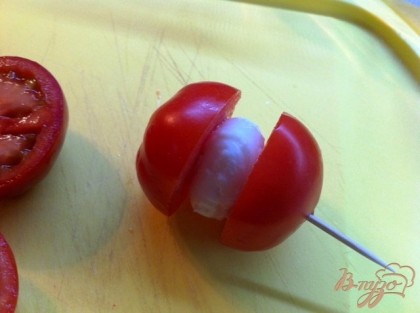 Между каждой половинкой помидора кладем шарик моцареллы и накалываем на зубочистку.