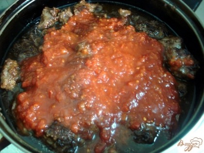 К мясу добавляем томатный соус и вино и тушим до готовности мяса.