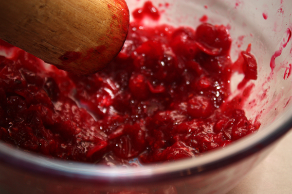 Небольшими порциями откладываем ягоды в неокисляемую посуду и тщательно разминаем деревянной толкушкой.  Не используйте на этом этапе металлическую посуду, иначе в готовом продукте будет чувствоваться металлический привкус.
