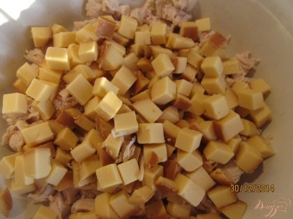 Колбасный сыр нарезаем кубиками. Кубики необходимо разделить руками, так как они могут остаться склеянными в салате.