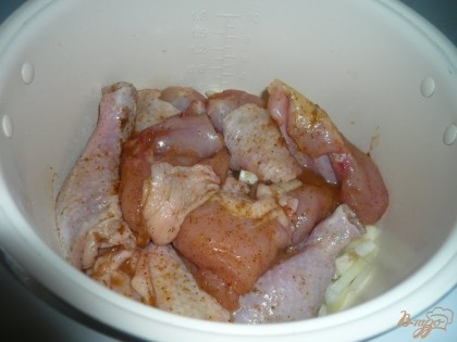 После этого выкладываем на лук кусочки курицы. Если в посуде о курицы остался соус – выливаем его в чашу мультиварки.