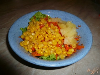 Добавляем к салату пикантную морковь, кусочки ананасов, пару столовых ложек кукурузы.