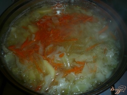 Когда капуста проварится, добавляем к ней картофель и морковь.