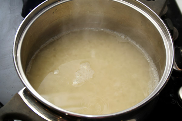 Рис пересыпать в кастрюлю и залить горячим бульоном. Отварить рис до полу готовности, он должен быть в центре чуть-чуть твердым.