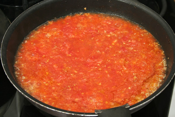Добавить в сковороду тертые помидоры, немного их спассеровать и добавить горячий бульон, соль.