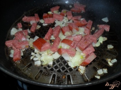 Лук и колбасу нарезаем, жарим на разогретой сковороде с растительным маслом