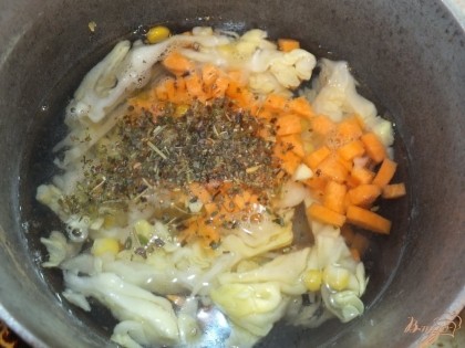 В кипящую воду кладем морковку, капусту, травы, соль и душистый перец, добавляем масло. Варим 7 мин. Добавляем капусту и варим до готовности морковки и капусты. Солим суп по вкусу.