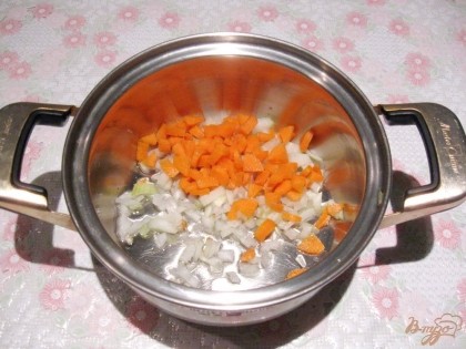 Морковь чистим и моем, мелко нарезаем. Кладем к луку. Ставим на плиту и припускаем овощи 10 минут на небольшом огне.