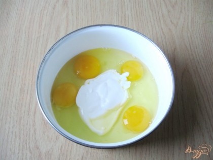Яйца разбиваем в миску. Добавляем сметану и солим по вкусу.