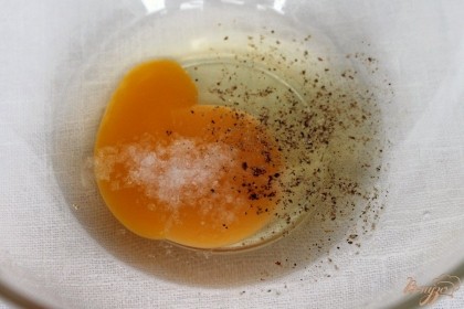 В пиалу разбиваем яйцо, добавляем соль и черный молотый перец.  Все перемешиваем.