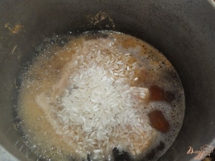 Всыпаем рис и вливаем горячей воды чтобы покрыть его на 4 пальца.