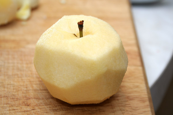 Очистить яблоко и потереть половину на мелкой терке. Разложить следующим слоем по формам.