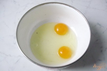 В миску разбиваем два яйца.