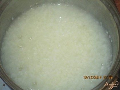 Рис поместить в кастрюлю и залить 0,5 литрами воды и довести до кипения, убавить огонь и варить до повного в выпаривания воды периодически помешивая (8-10)мин.