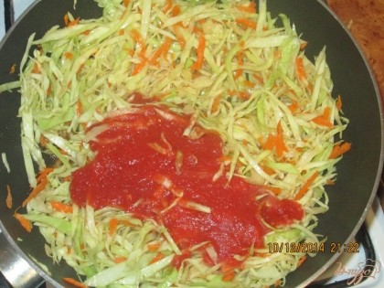 Приступим к приготовлению начинки для вареников. На режим капусту и натрем морковь. На разогретую сковородку с подсолнечным маслом бросим капусту и морковь и все это залем 100 грамами томатного сока  накроем крышкой и дадим потушиться 10-15мин.