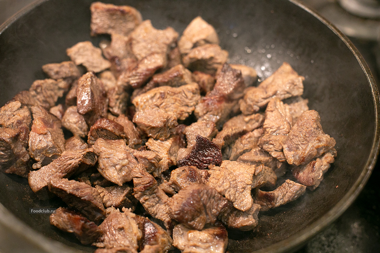 Как только мясо станет мягким, нужно его посолить, добавить репчатый лук и специи.