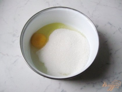 В миску разбиваем яйцо, добавляем сахар и перемешиваем ложкой или взбиваем миксером.