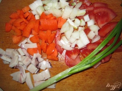 Нарезаем лук, половину помидора и моркови. И нарезам плавник кальмара.