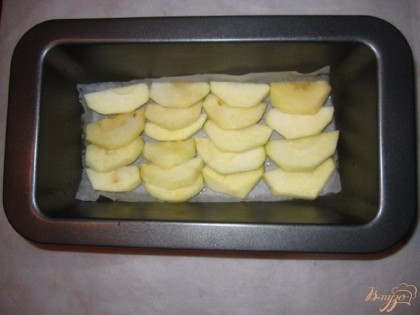 Яблоки очистить от кожуры, нарезать дольками.Дно формы застелить бумагой для выпечки, смазать растительным маслом. Выложить яблоки.