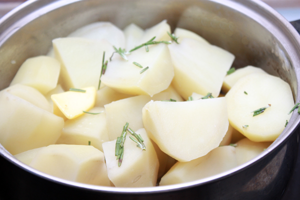 Картошку нужно очистить, разрезать на 2 или 4 части в зависимости от размера и сварить в подсоленной воде так, чтобы она осталась немного недоваренной.  Воду слить, а картофель посыпать измельченными листиками розмарина.