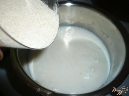 Молоко довожу до кипения и тонкой струйкой засыпаю манку с сахаром. При этом молоко постоянно помешиваю.