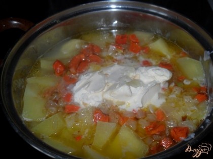 Когда картофель закипит, солим, перчим, добавляем сливки, лук и морковь.