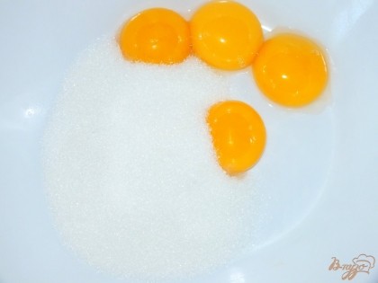 Желтки растереть с 0,5 стакана сахара и ванилином в белую массу.