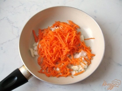 Морковь и репчатый лук чистим, моем.  Лук мелко режем, а морковь трем на терке.  На сковороду наливаем подсолнечное рафинированное масло и тушим овощи на небольшом огне 7-8 минут.