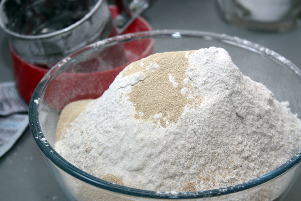 Муку просеиваем в миску, добавляем соль, сахар и дрожжи.