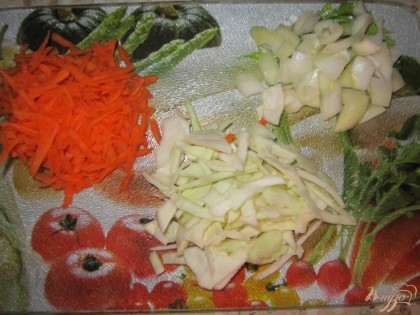 Тем временем очищаем овощи. Лук нарезаем мелкими кубиками, морковку натираем на крупной тёрке, а капусту мелко режим.