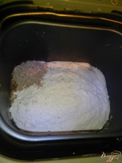 Закладывать ингредиенты по инструкции используемой хлебопечки. В моей – с начала жидкие, затем сухие. Налить в ведёрко хлебопечки растительное масло, выложить опару для хлеба, затем 190 грамм муки, овсяные хлопья, отруби и соль.