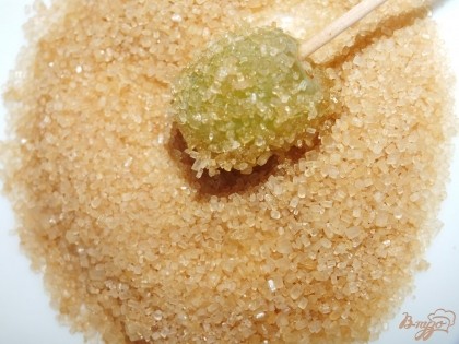 Тем временем делаем засахаренные фрукты для верхушки торта. Желатин залить 100 мл воды. Когда он набухнет, поставить на огонь и прогреть, не доводя до кипения, до полного растворения желатина. Снять с огня. В одну миску перелить желатин, в другую насыпать универсальный коричневый сахар. Опускать каждую виноградину сначала в миску с желатином, затем в сахар. Выкладывать на салфетки. Так же обработать дольки киви и цитрусовых
