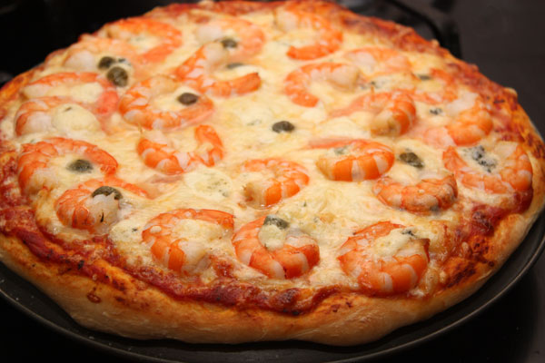 Печь пиццу нужно в очень горячей духовке (220-250 градусов) на среднем уровне около 10 минут.  Точные цифры зависят от вашей духовки, так что следите внимательно!