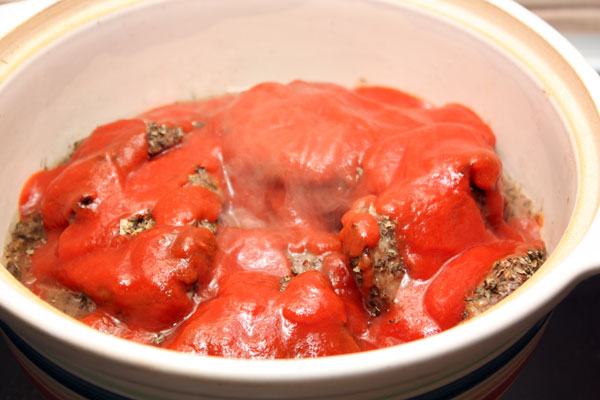 Добавить к мясу томатное пюре (можно также использовать свежие очищенные от кожуры и мелко нарезанные помидоры).