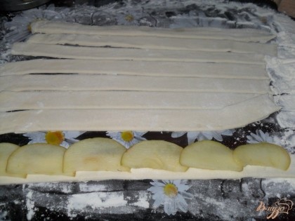 Тесто розморозить. Тесто раскатать толщиной в 1-2 мм, и длинной в 25-30 см. Затем разрезать тесто на полоски по 2-3 см. на полоску выкладываем яблоки 5 долек, слегка внахлест.
