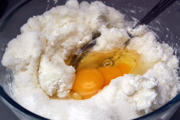 Сначала нужно сварить рис и промыть его.  Затем добавить в рис творог, сахар, соль и яйца.