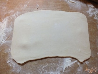 Раскатываем слоеное тесто в квадрат толщиной примерно в 0.7-1 см. Тонкий лист не подойдет- ушки будут плоские.