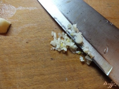 Ножом измельчаем чеснок так, чтобы его было видно на шпинате (не совсем мелко).
