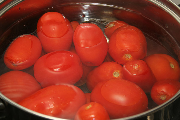 В жгучий кипяток опустить вымытые помидоры на 2-3 минуты.