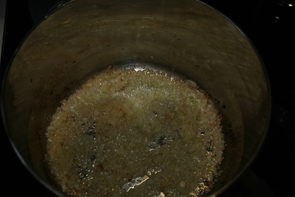 Разогреть в кастрюле оливковое масло и закинуть чеснок и лук. Овощи слегка подрумянятся, а масло должно дать сильный аромат.