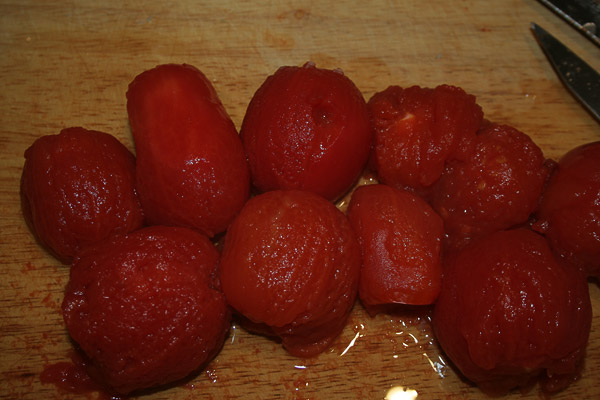 Очистить томаты от кожуры, нарезать и добавить в кастрюлю.