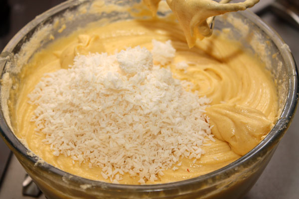 Теперь в тесто добавляем муку, разрыхлитель, ванильный сахар, все это взбиваем и кладем кокосовую стружку для аромата и текстуры будущего пирога.